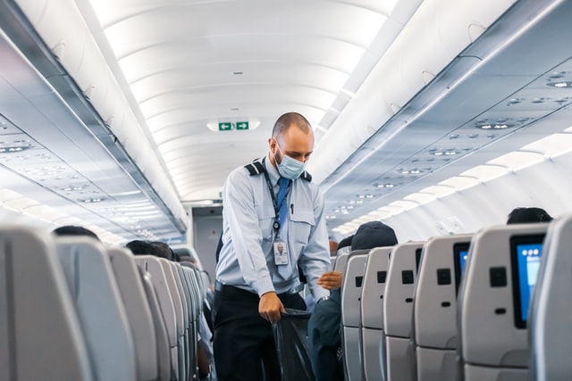 man with uniform and mask on a plane